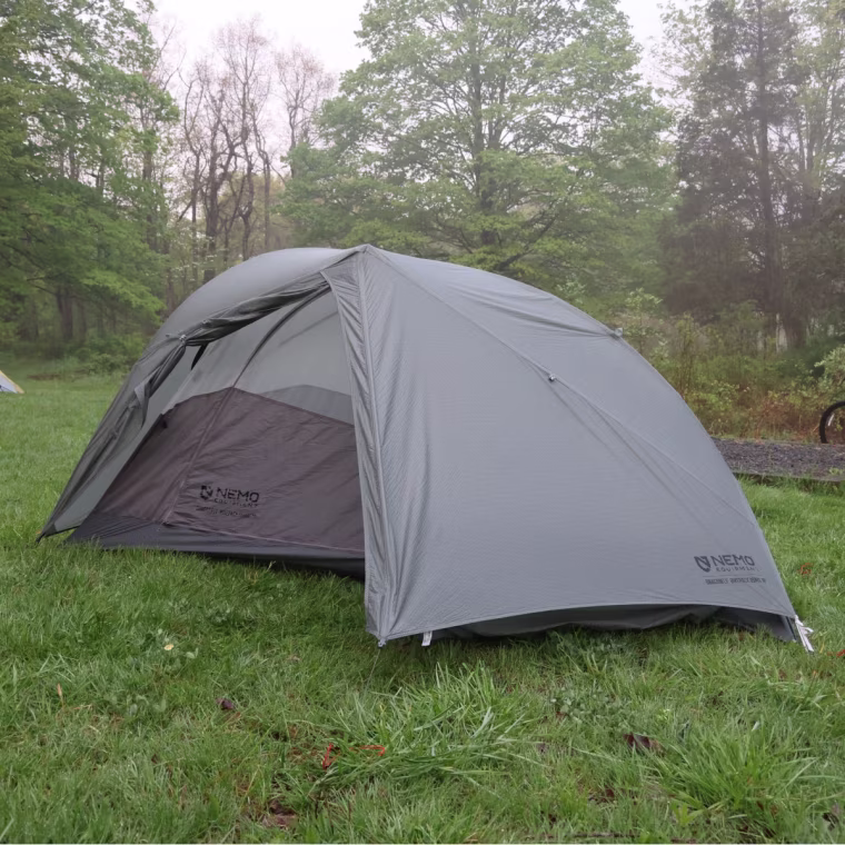 A picture of the Nemo Dragonfly OSMO Bikepack Tent set up in a grassy field.