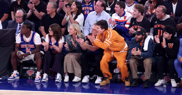 Celebrities sit courtside.