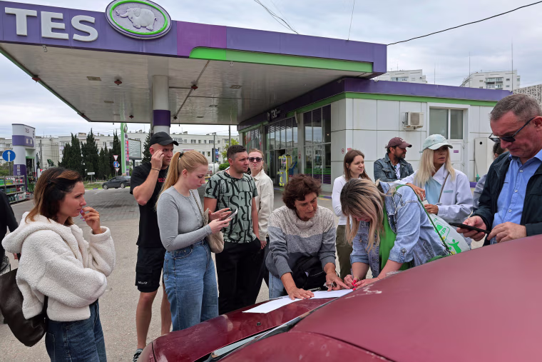 People put their names on a list to join the queue for fuel at a gas station in Sevastopol