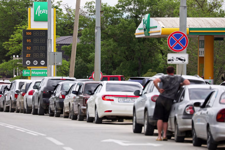 Cars queue for fuel at a gas station in Saki