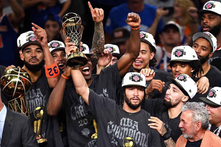 New York Knicks players group together to celebrate as Jalen Brunson, center, holds the MVP trophy