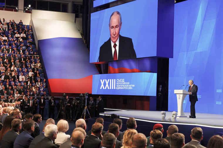 Image: Vladimir Putin on stage addressing an audience
