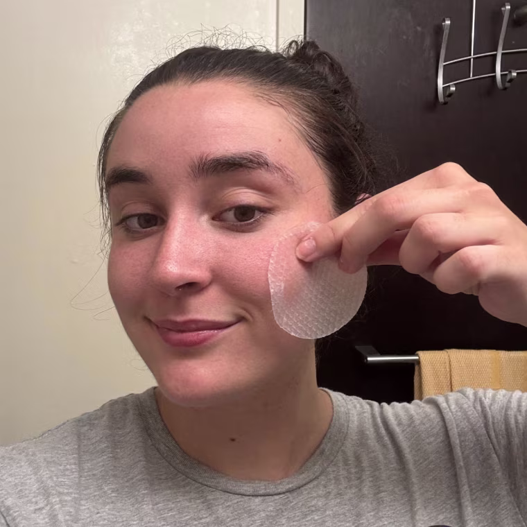 Woman applying toner pad to face