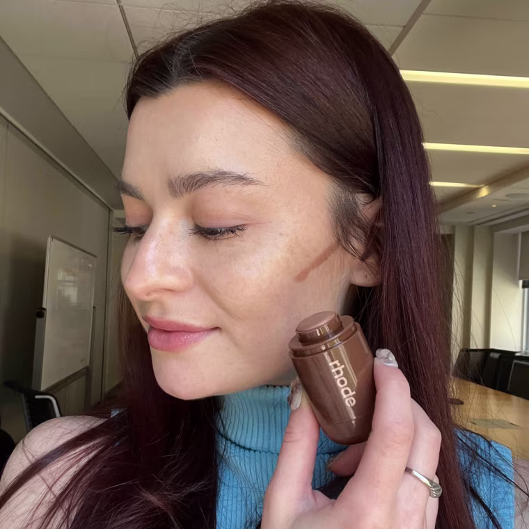 Associate market editor Audrey Ekman applies the Rhode Pocket Bronze in the shade pebble.