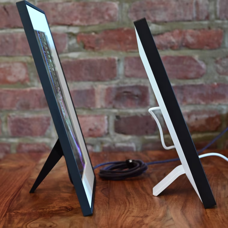 An image of the Aura Aspen and Skylight Frame 2 side by side on a table, in-profile.