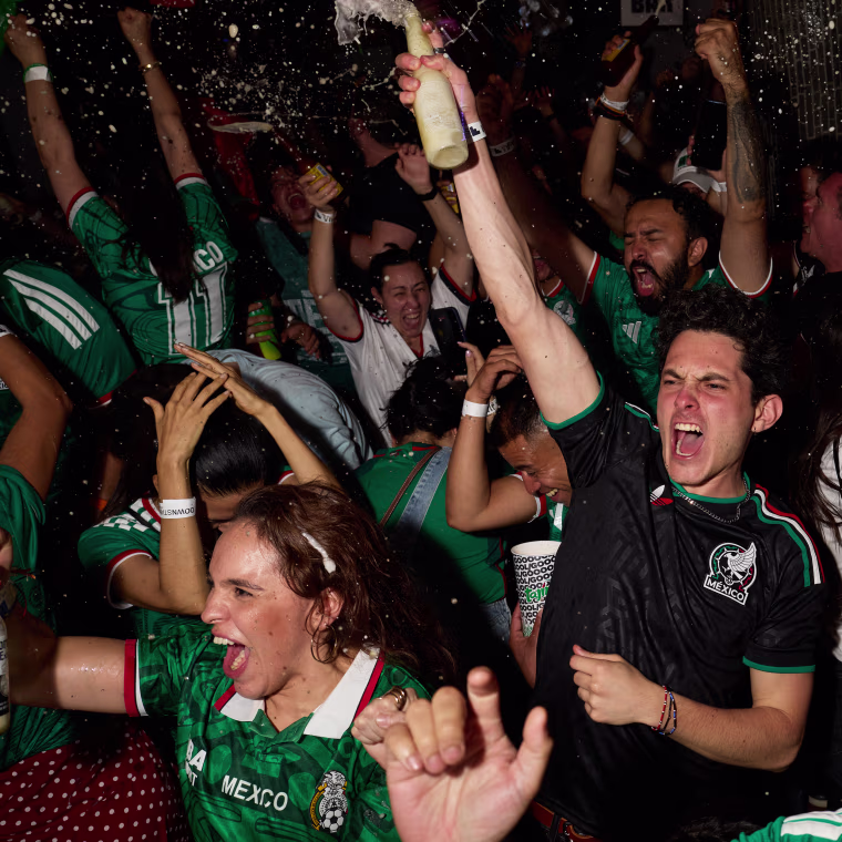 Image: Mexico football fans celebrate, spraying bottles of alcohol