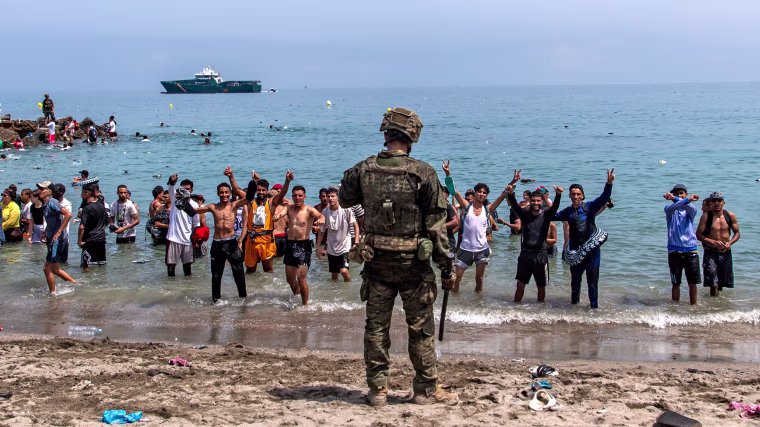 Spanish army soldiers block access to the beach for people crossing from Morocco into the Spanish enclave of Ceuta, Friday, July 31, 2026. 