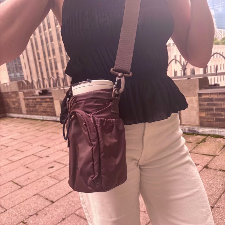 Woman wearing Calpak brown Water Bottle Holder outside.