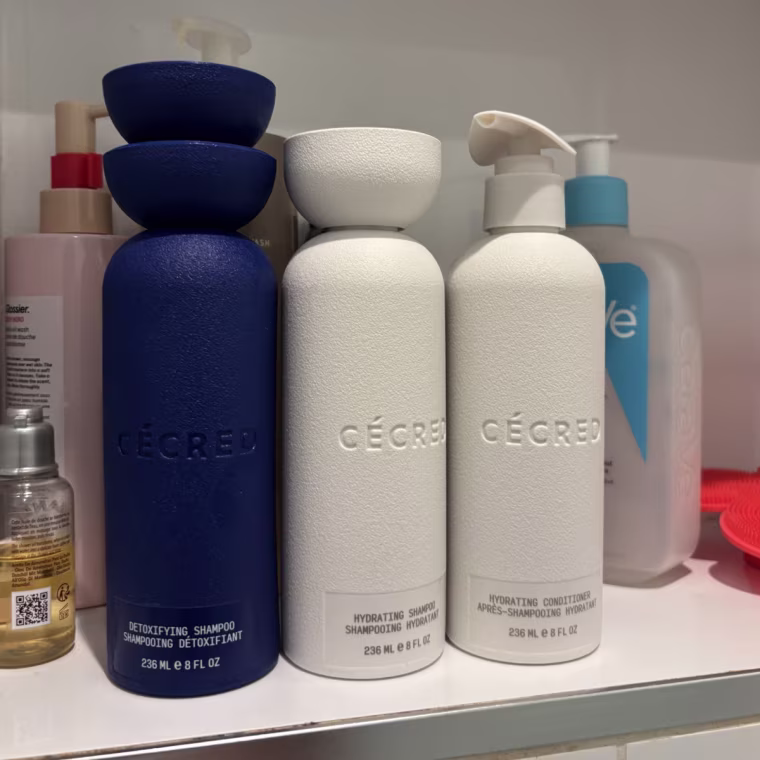 The Cecred Detoxifying Shampoo, Hydrating Shampoo and Hydrating Conditioner lined up on a shower shelf.