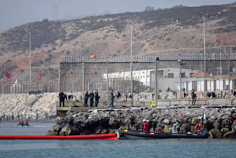 A 500-meter-long (1,640 feet) pneumatic barrier is deployed in the water by a Spanish Guardia Civil boat.