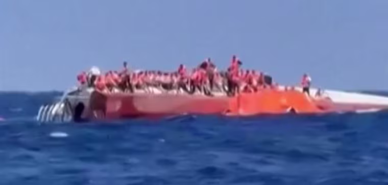 Passengers stand on a capsized ship off northern Cyprus as they await rescue Sunday.
