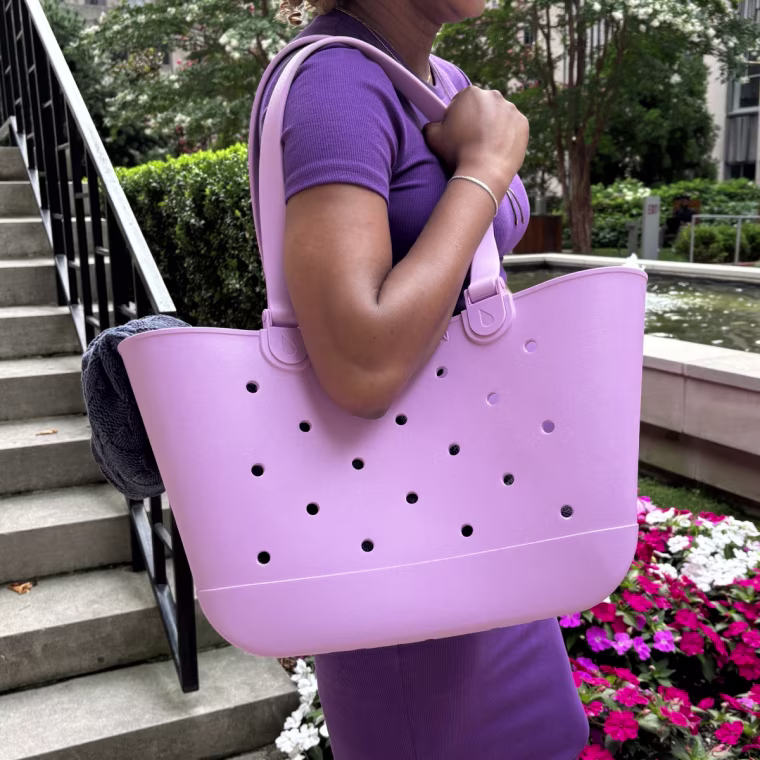 Woman holding pink Simple Modern Getaway tote.