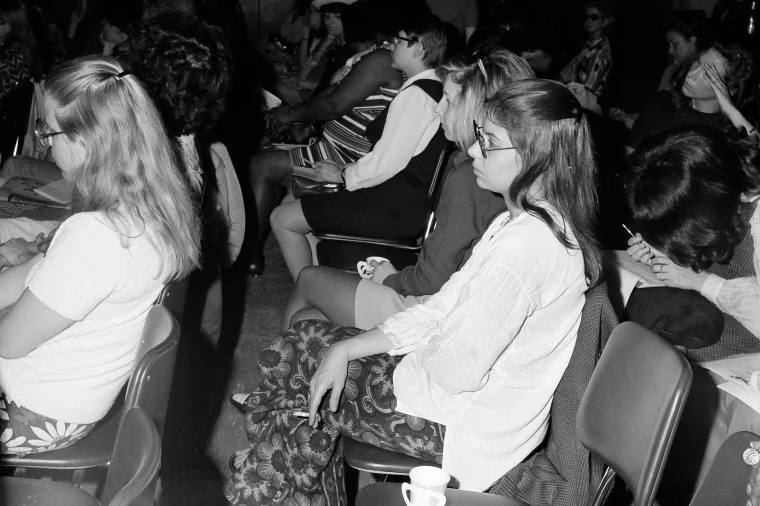 A black-and-white photo of several young women seated in rows of chairs.