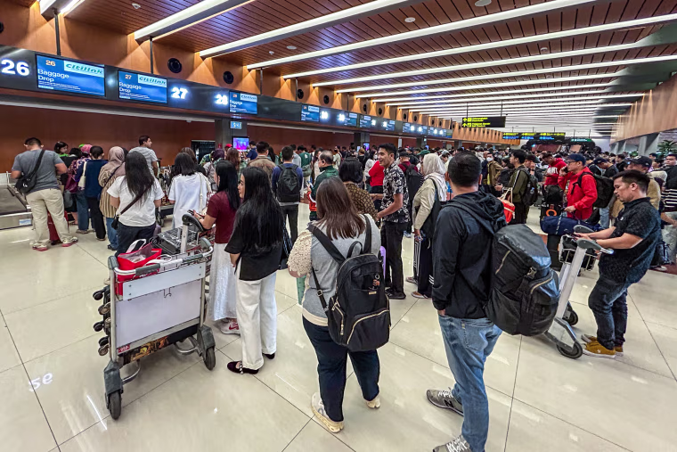 Passengers wait in long lines inside of an airport