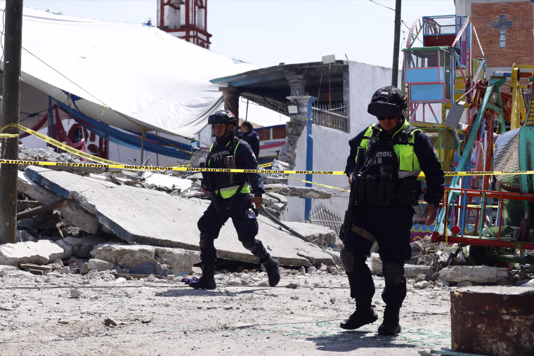 Mexican State Police officers inspect the site of a fireworks blast in Santa Maria Canchesda, Mexico state, Mexico on September 6, 2026. A fireworks explosion at a church while hundreds of people were celebrating a patron saint's festival in Mexico killed at least 10 people and left more than 60 injured, authorities reported September 6, 2026. 