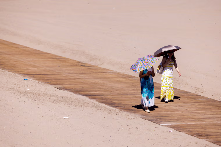 People walk with umbrellas.