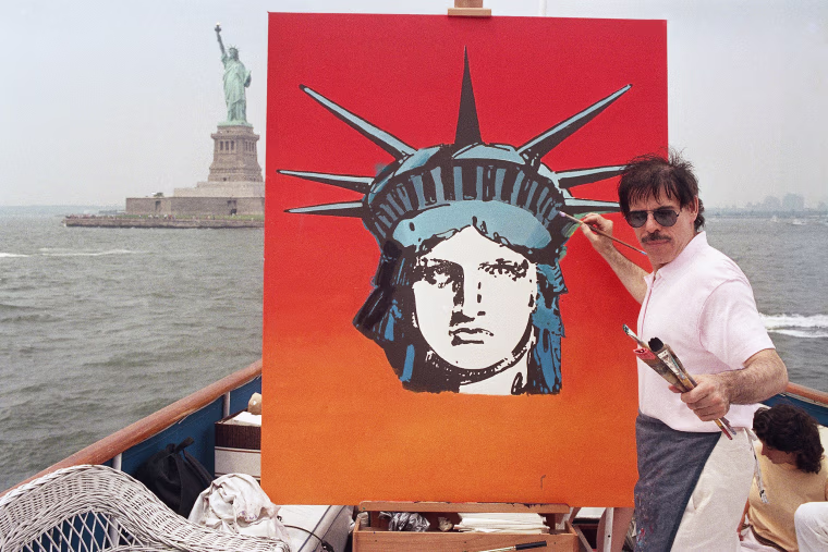 Artist Peter Max works on a painting of the Statue of Liberty while on a boat.