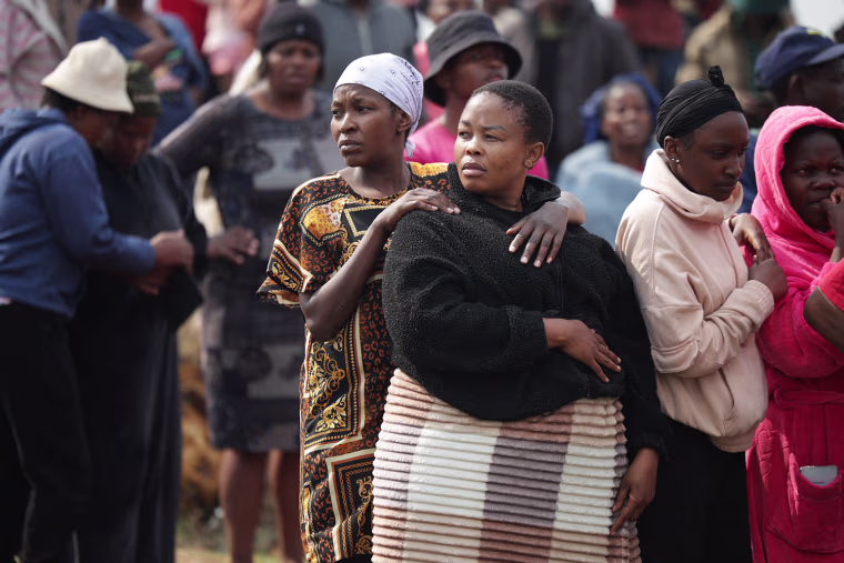 People gather near the crime scene where the body of a woman was discovered in Boksburg on September 17, 2026. 