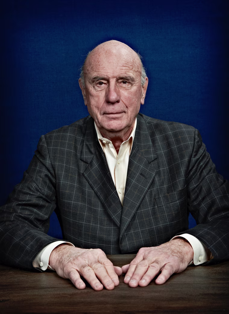 Bob Betitt photographed while seated in front of a neutral blue backdrop.