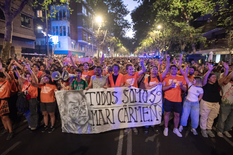 People hold a banner reading "We are all Maricarmen"