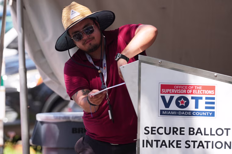Un miembro del personal electoral deposita una boleta de voto por correo en un contenedor seguro en la Oficina del Supervisor de Elecciones del condado de Miami-Dade en Doral, Florida, el 18 de agosto de 2026.