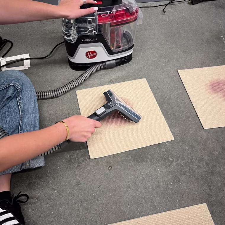 Going over the red wine stain with the Hoover portable carpet cleaner.