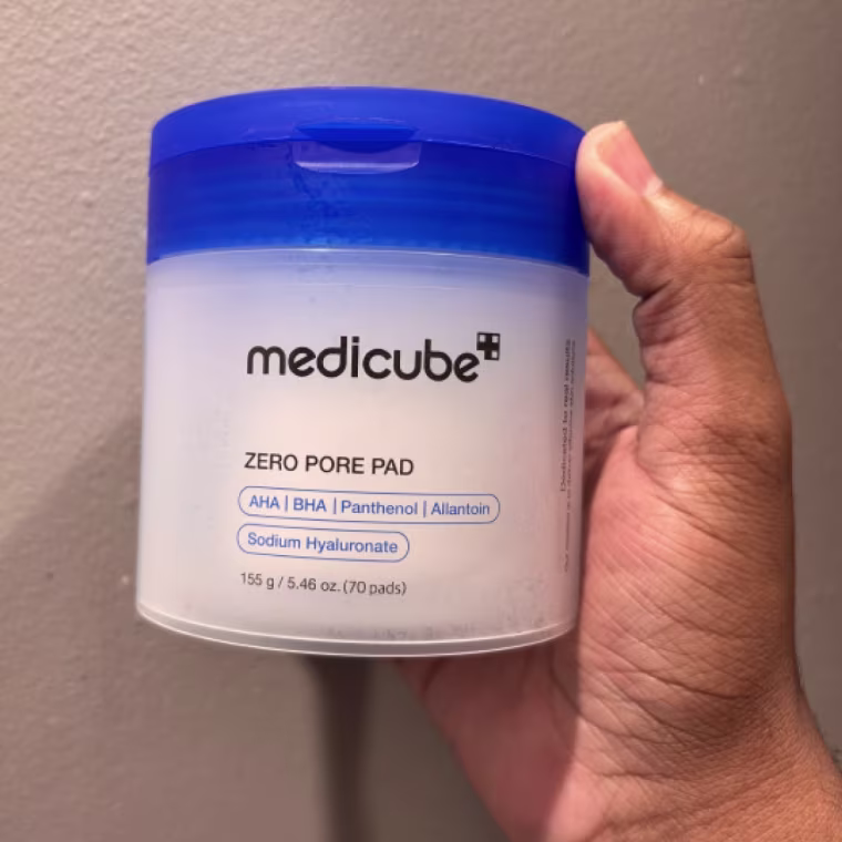 Person holding container of Medicube Zero Pore Pads.