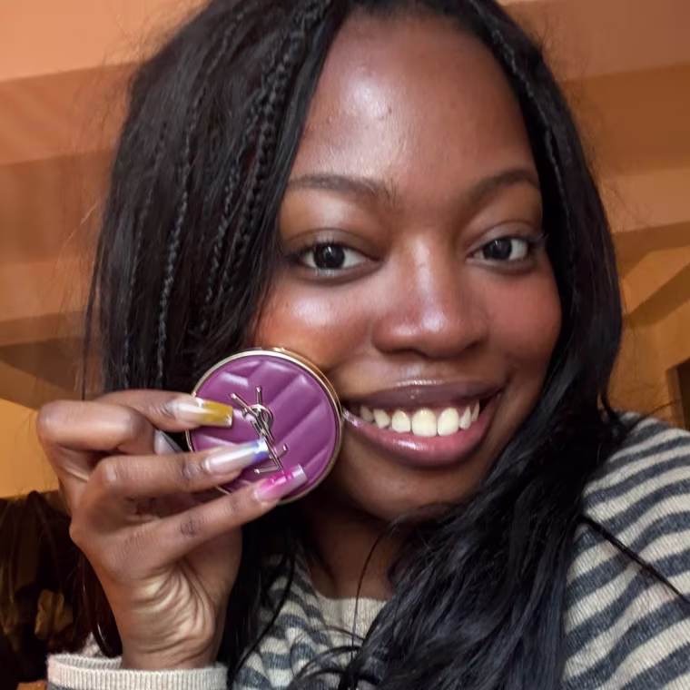Person smiling while holding a purple YSL blush