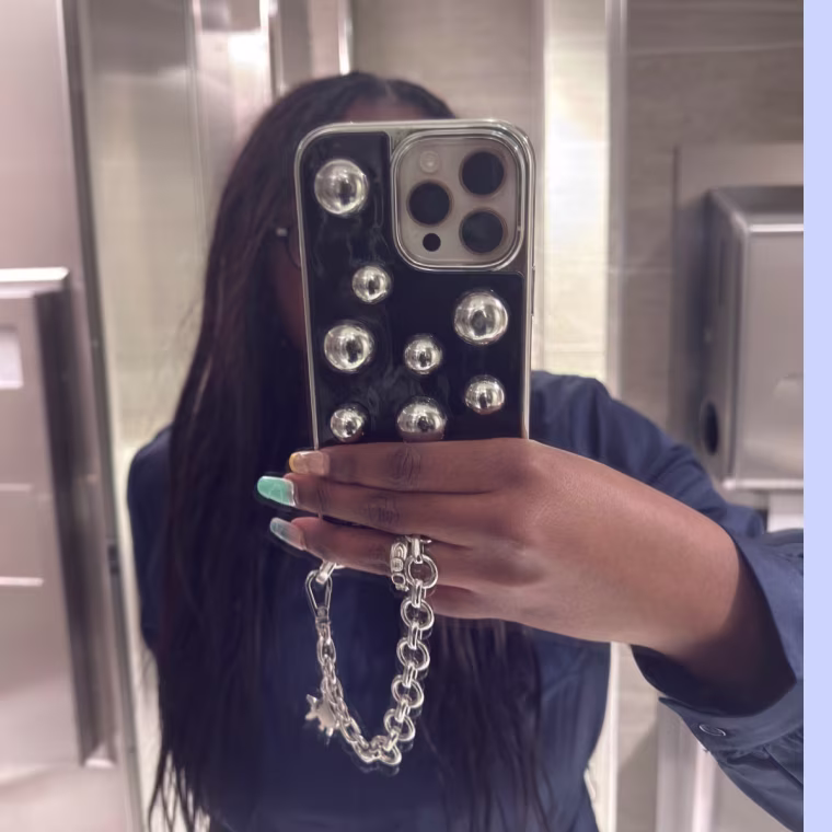 Mirror selfie showing a black and silver sculptural phone case.