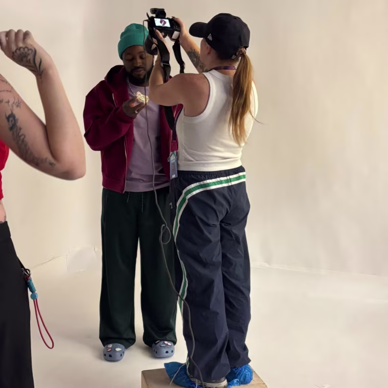 Person wearing Gap × Malbon Textured Poplin Barrel Track Pants and holding a camera.