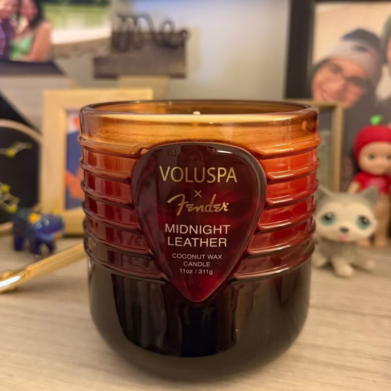 Voluspa x Fender Midnight Leather candle on a bookshelf