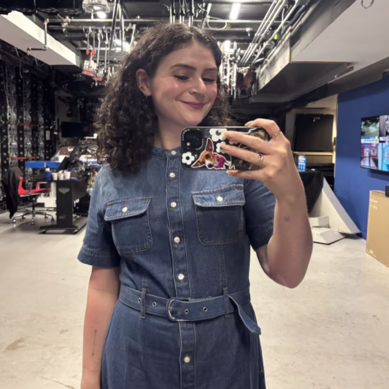 A woman taking a picture in a mirror while wearing Ann Taylor’s Weekend Belted Denim Shirtdress.