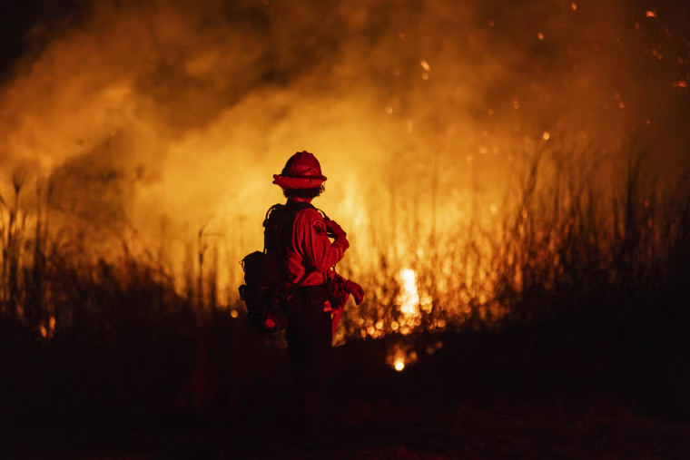 A firefighter monitors the spread of fire.
