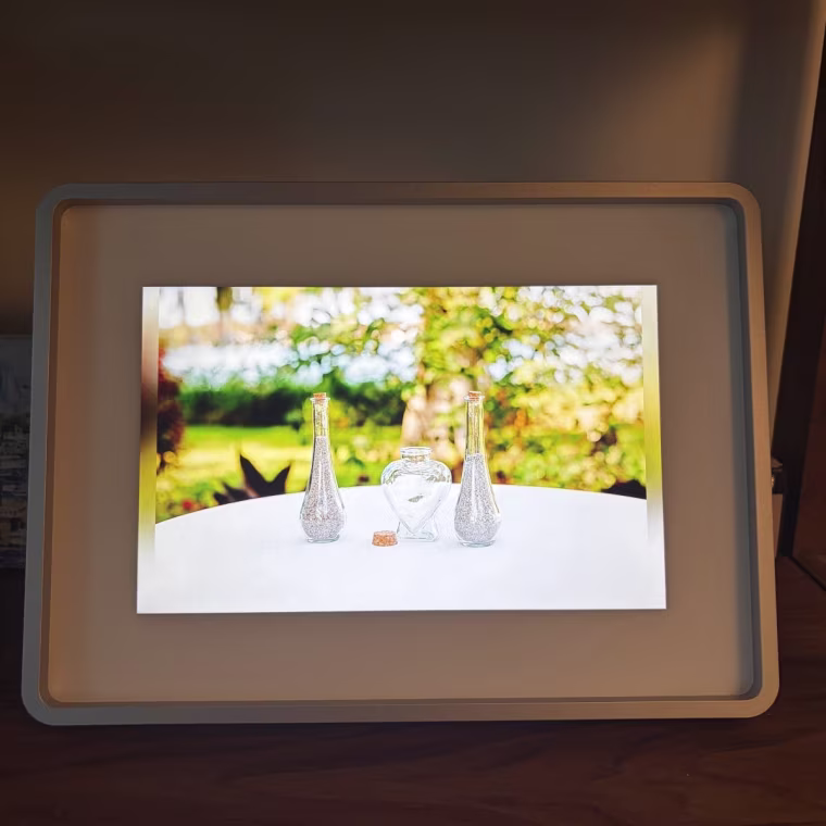 A smart frame with a photo of vases on a white table