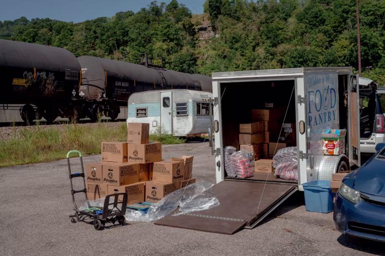 A stack of food boxes for seniors sat outside Donna Paterino's trailer in Williamson. Paterino packed them up to hand out later that afternoon to local seniors.