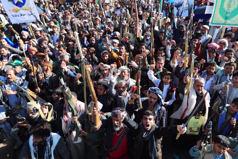 Fighters loyal to the Houthi party rally with their weapons in Yemen.