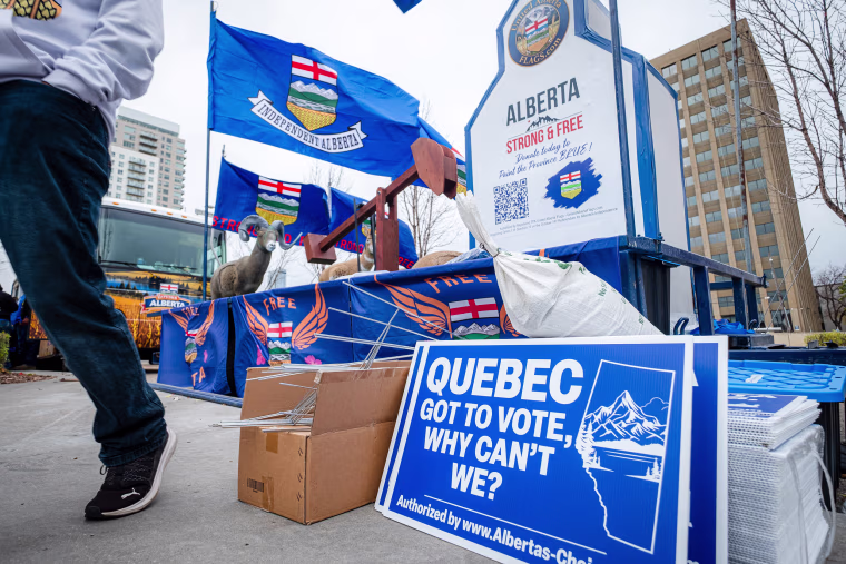 Image: An Alberta independence rally, with a blue sign in the foreground that reads 