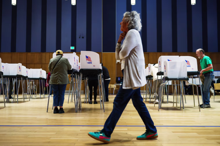 An election worker watches as people cast their ballots at the polling center at the Silver Spring Civic Building on October 22, 2026 in Silver Spring, Maryland. 