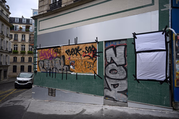 Commercial establishments, bank branches, and luxury boutiques in central Paris are seen securing their storefronts with wooden protective panels and metal barricades.