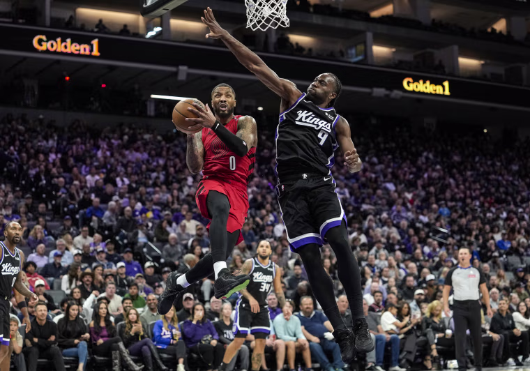 Damian Lillard #0 of the Portland Trail Blazers and Precious Achiuwa #9 of the Sacramento Kings.