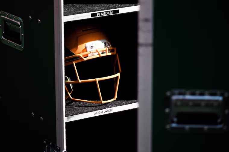 A football helmet sitting in the shadows.