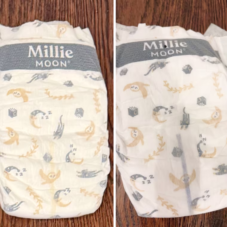 Side-by-side photos of a Millie Moon diaper with a sleepy moon and cat print, showing a yellow wetness line on the left and a purple line on the right.