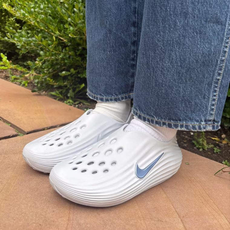A person wearing the Nike ReactX Rejuven8 recovery slides.