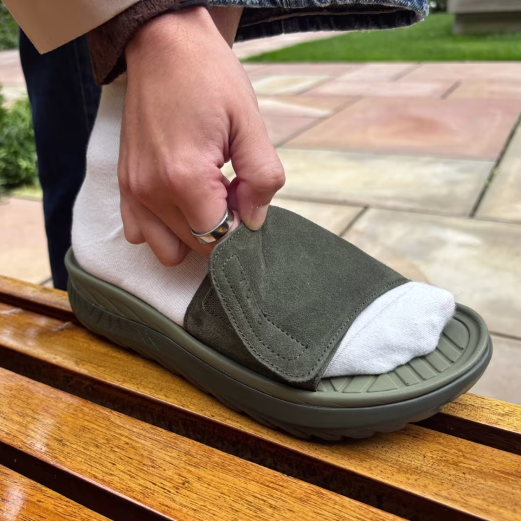 A person adjusting the strap on Vionic’s Rejuvenate Recovery Sandal.