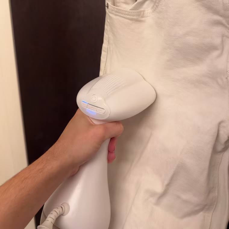 Nori Cloud Garment Steamer being used to steam white denim jeans.