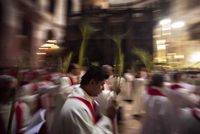 Catholic priests carry palm fronds at the Church of the Holy Sepulchre, traditionally believed by many to be the site of the crucifixion and burial of Jesus Christ, in Jerusalem's Old city, April 1. Palm Sunday marks for Christians Jesus Christ's entrance into Jerusalem when his followers laid palm branches in his path, prior to his crucifixion.