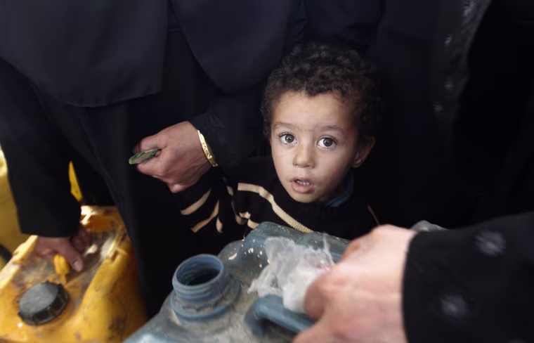 A Palestinian boy waits along with other residents wait in a queue to fill containers with fuel at a petrol station in Gaza City on April 2, 2012.