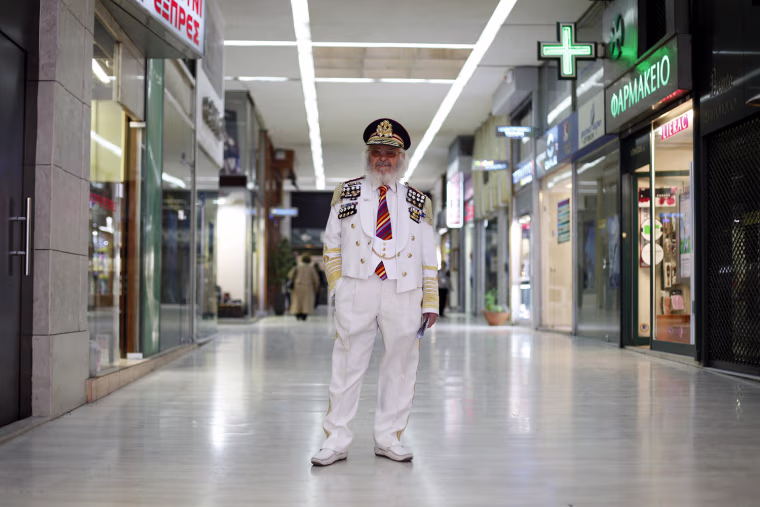 Christos Vassiliou, 79, retired sausage maker, poses for a picture in a shopping centre in central Athens on March 28. When asked how he had been affected by the economic crisis, Vassiliou replied, 'my pension has been cut by 250 euros ($334) a month. If it continues like this I will be thrown out of my house because I can't afford my rent.'