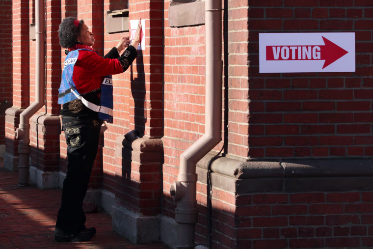 Election worker Marline Coughman tapes a