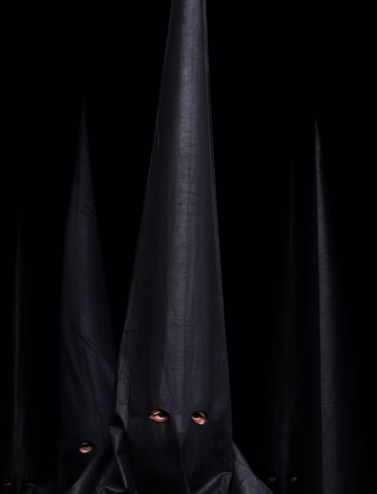 Penitents of 'Los Estudiantes' brotherhood in Seville leave their church on April 3 after their procession was canceled due to bad weather during Holy Week in southern Spain.